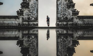 man standing between ruins in reflective photography