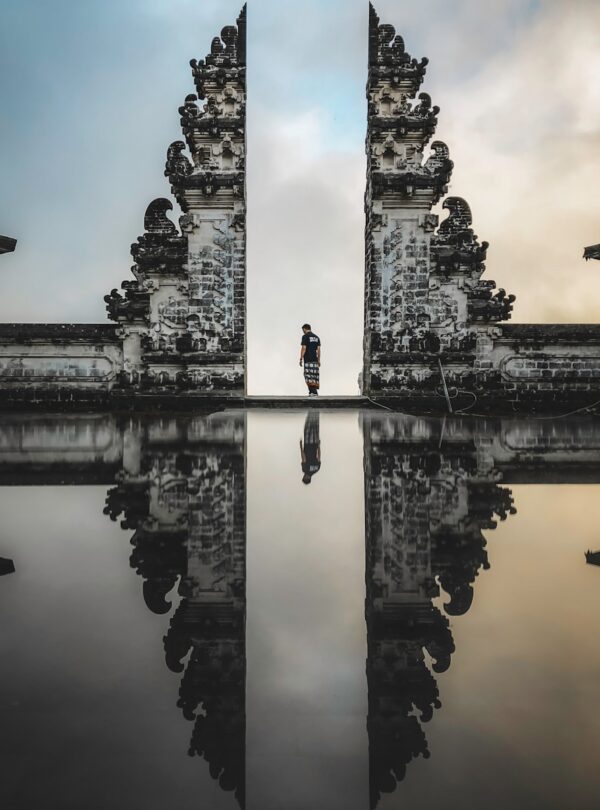man standing between ruins in reflective photography