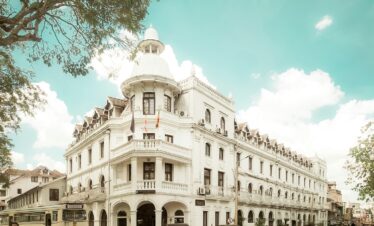 a large white building with a bus parked in front of it