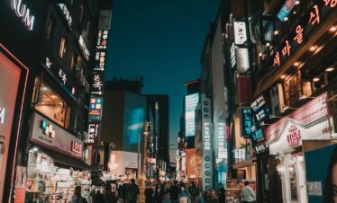 people walking between tall buildings