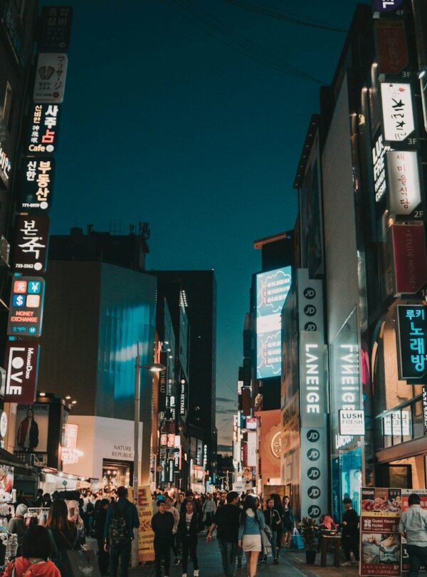 people walking between tall buildings