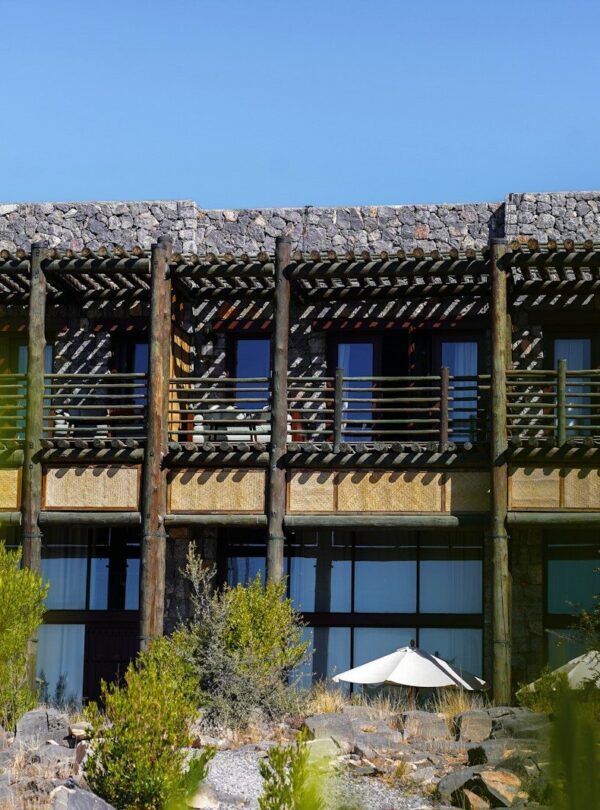 a tall building with a balcony and a white umbrella in front of it