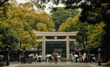 a group of people with umbrellas standing in front of a gate