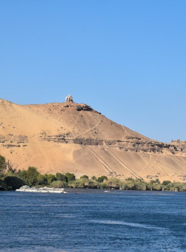 a sailboat in a body of water with a mountain in the background