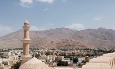 white concrete building near mountain during daytime