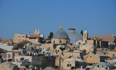 a city with a lot of buildings and a cross on top of it