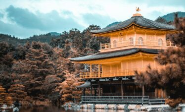 view of pagoda by water and trees
