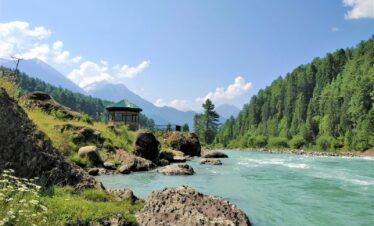 a small building on a rocky cliff over a body of water
