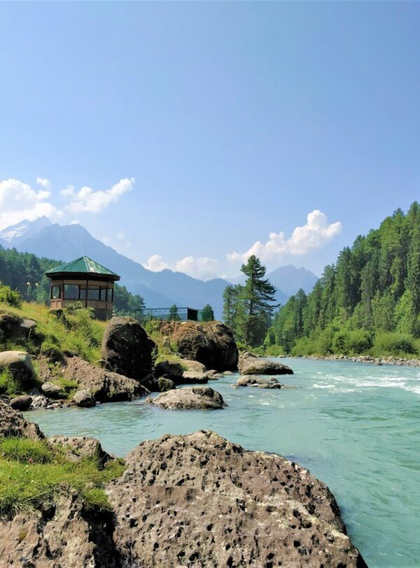 a small building on a rocky cliff over a body of water