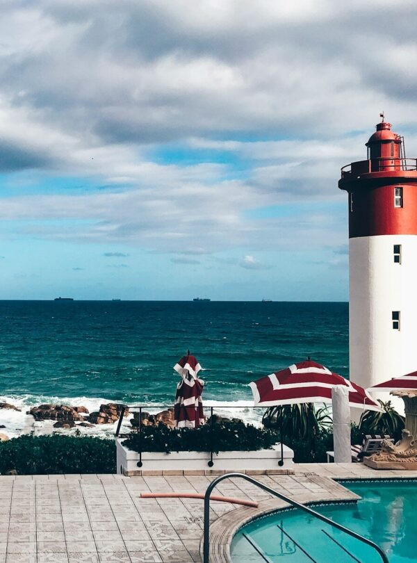 red and white lighthouse near body of water during daytime