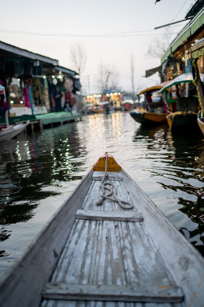 a boat floating down a river next to a bunch of buildings