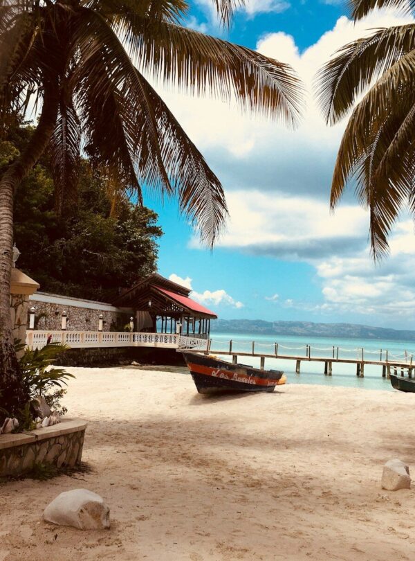 brown wooden boat on white sand near body of water during daytime