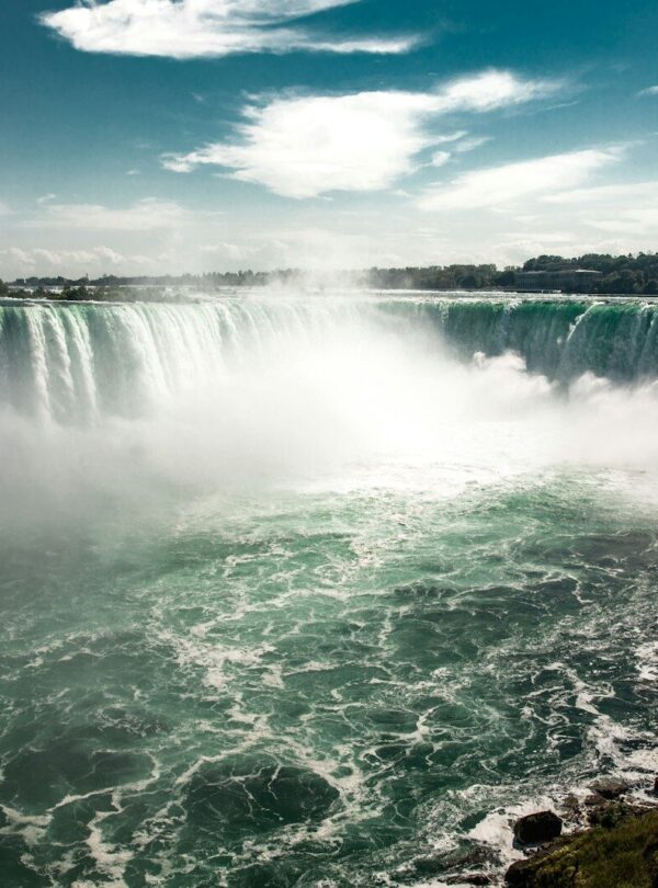 water falls under blue sky during daytime