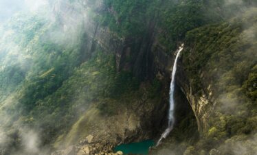 an aerial view of a waterfall in the mountains