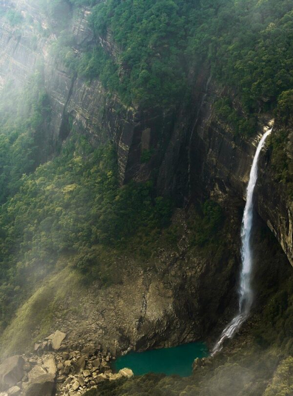 an aerial view of a waterfall in the mountains