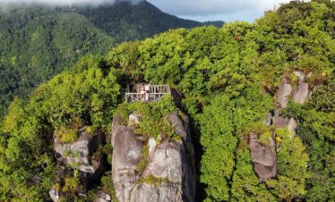 a couple of people standing on top of a wooden bridge