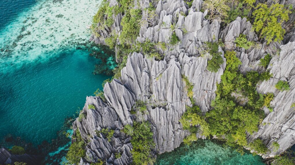 gray rock formation beside body of water during daytime