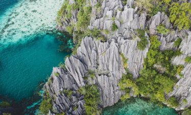 gray rock formation beside body of water during daytime