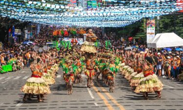 people in green and brown traditional dress walking on street during daytime