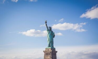 Statue of Liberty, New York under white and blue cloudy skies