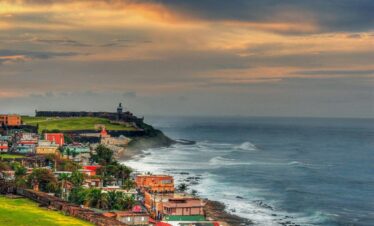 houses near sea under cloudy sky during daytime