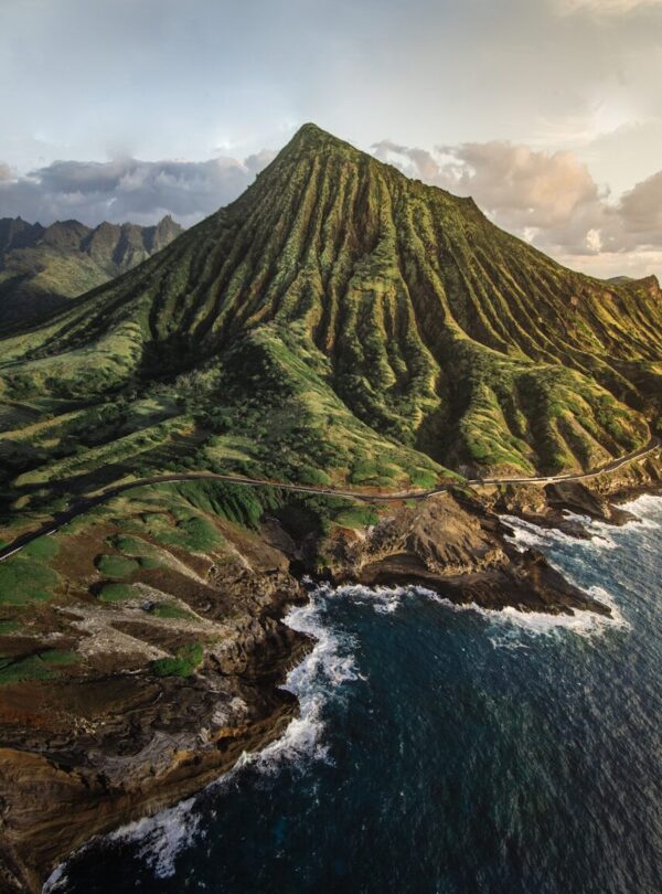 green mountain beside body of water during daytime