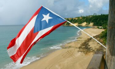 red and white flag on beach shore during daytime