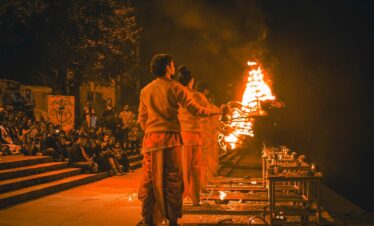 a couple of men standing in front of a fire