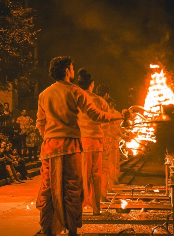 a couple of men standing in front of a fire