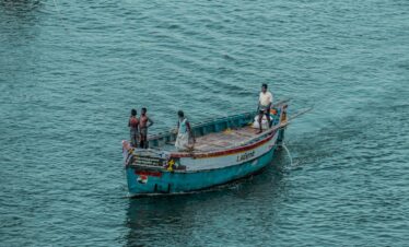 2 men and woman riding on boat on sea during daytime
