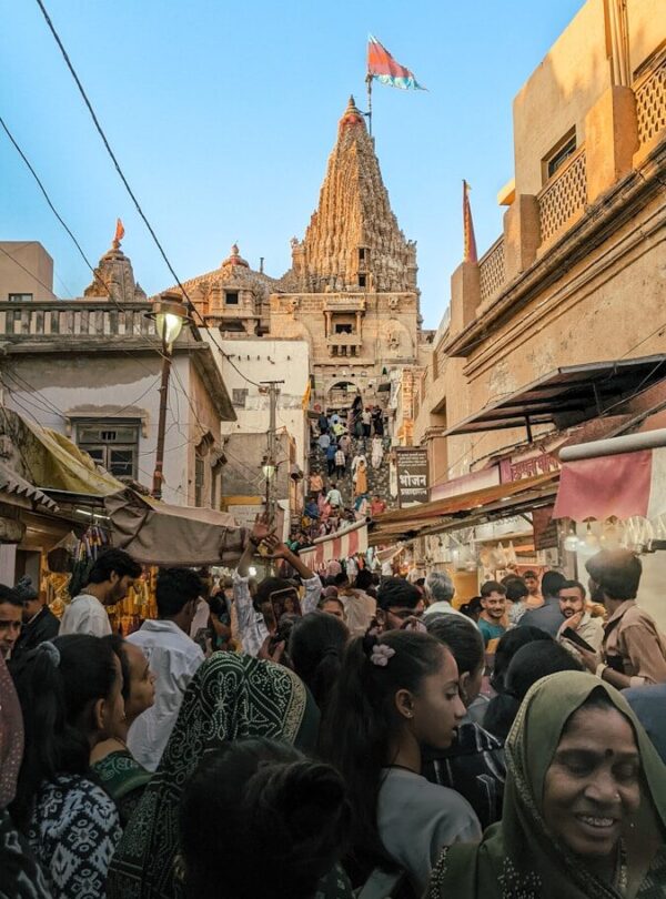 a crowd of people walking down a street next to tall buildings