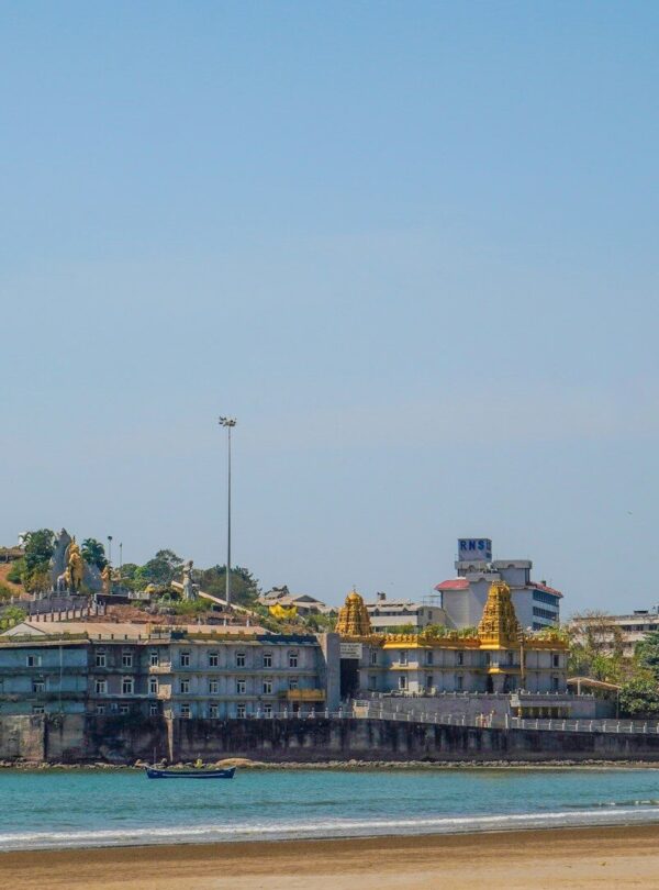 a tall tower with a statue on top of it next to a body of water