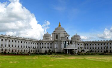 a large white building sitting on top of a lush green field