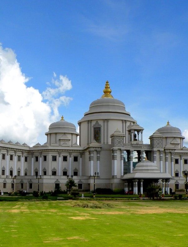 a large white building sitting on top of a lush green field